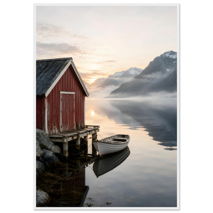 Rødt naust og hvit robåt ved en stille fjord med høye fjell og morgenlys