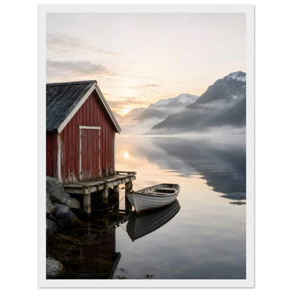 Rødt naust og hvit robåt ved en stille fjord med høye fjell og morgenlys