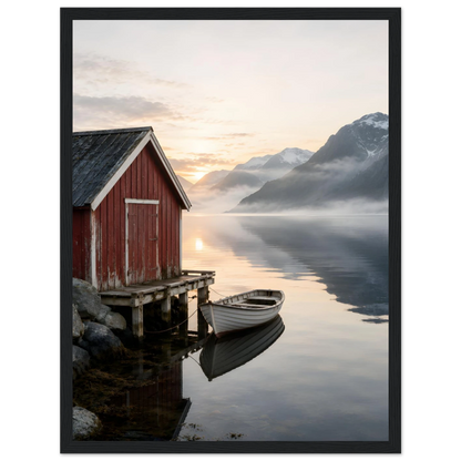 Rødt naust og hvit robåt ved en stille fjord med høye fjell og morgenlys